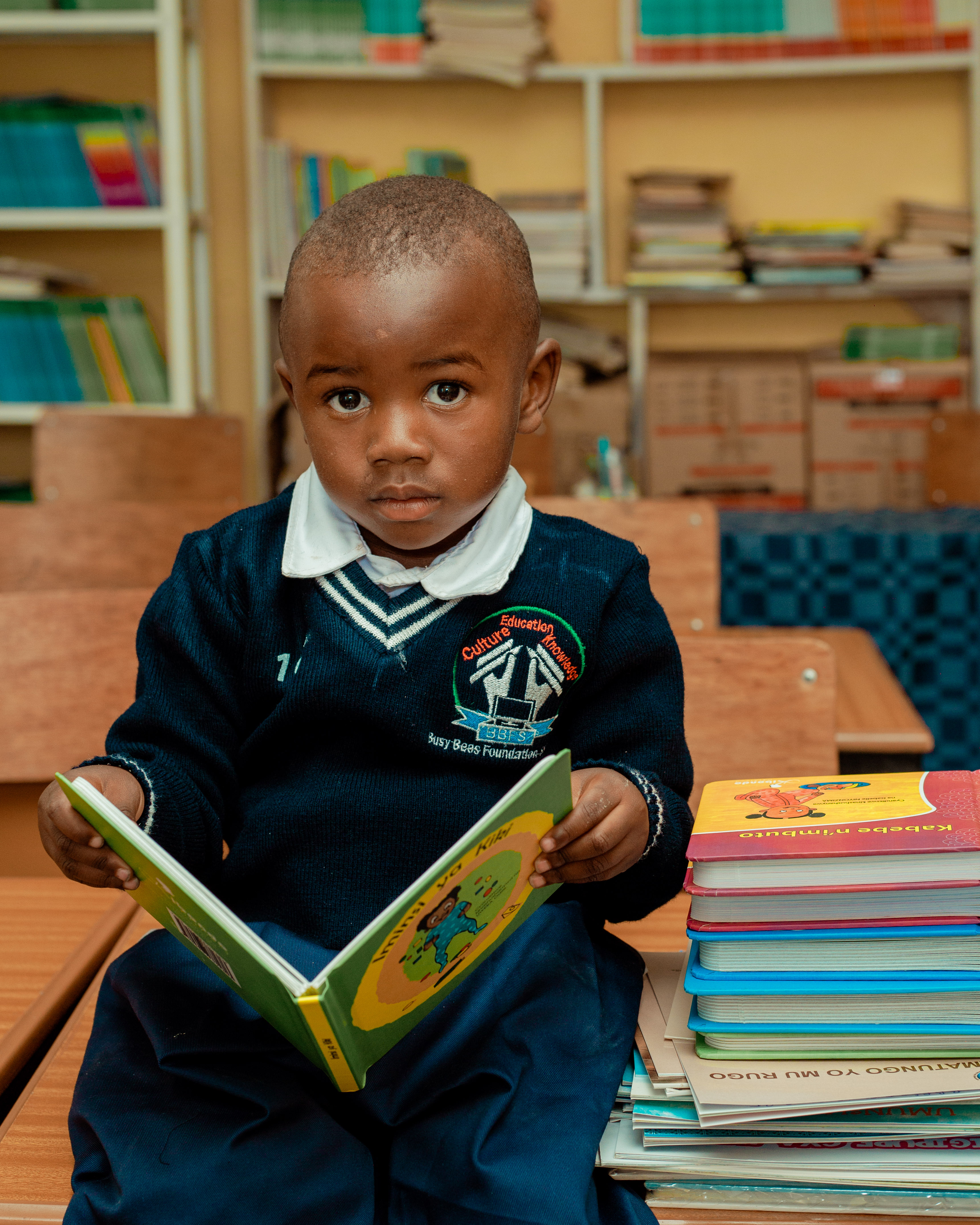 A young BBFS pupil reading in the school library